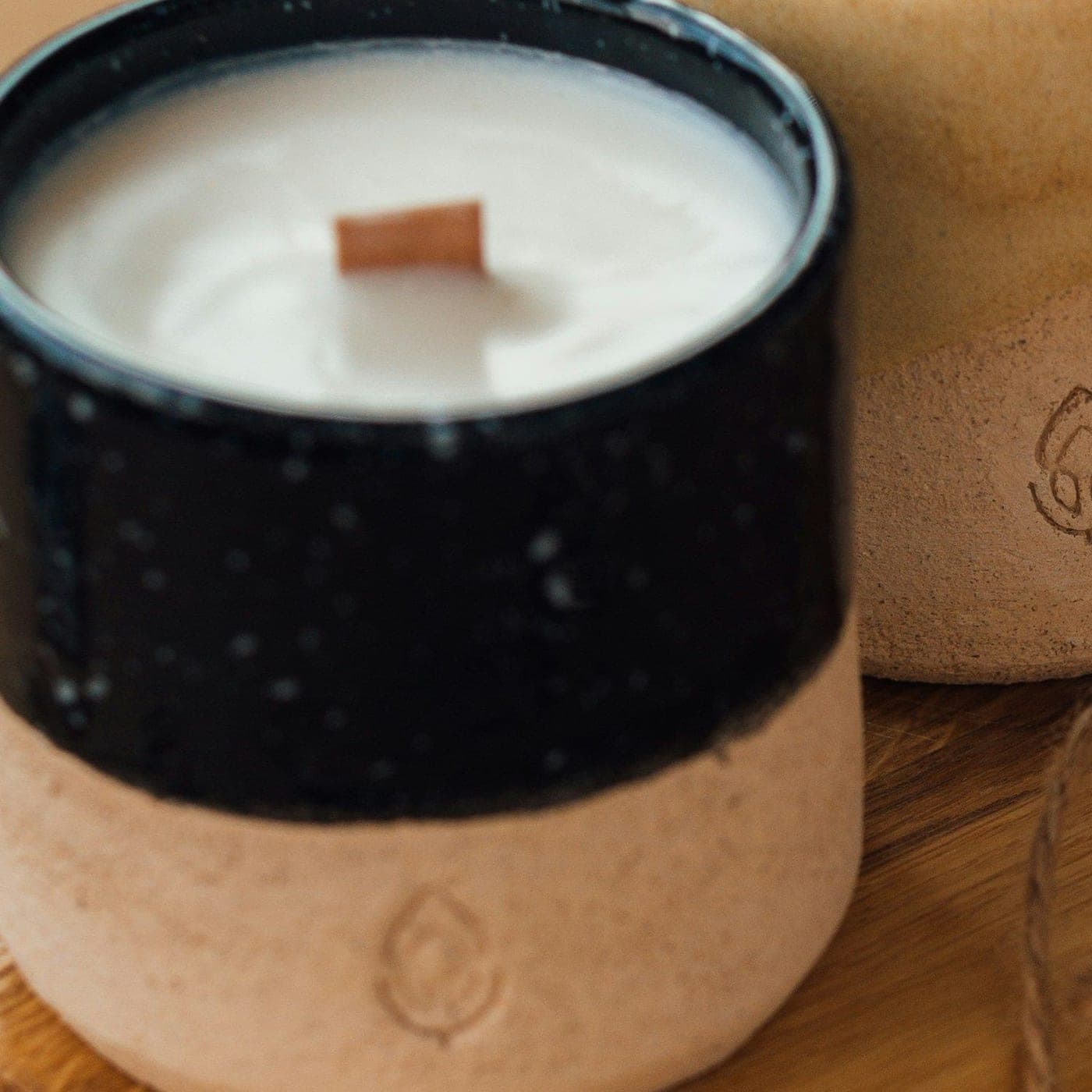 Rosewood Luxury Candle in Noir — A wooden-wick candle in a two-tone black and stone ceramic cup